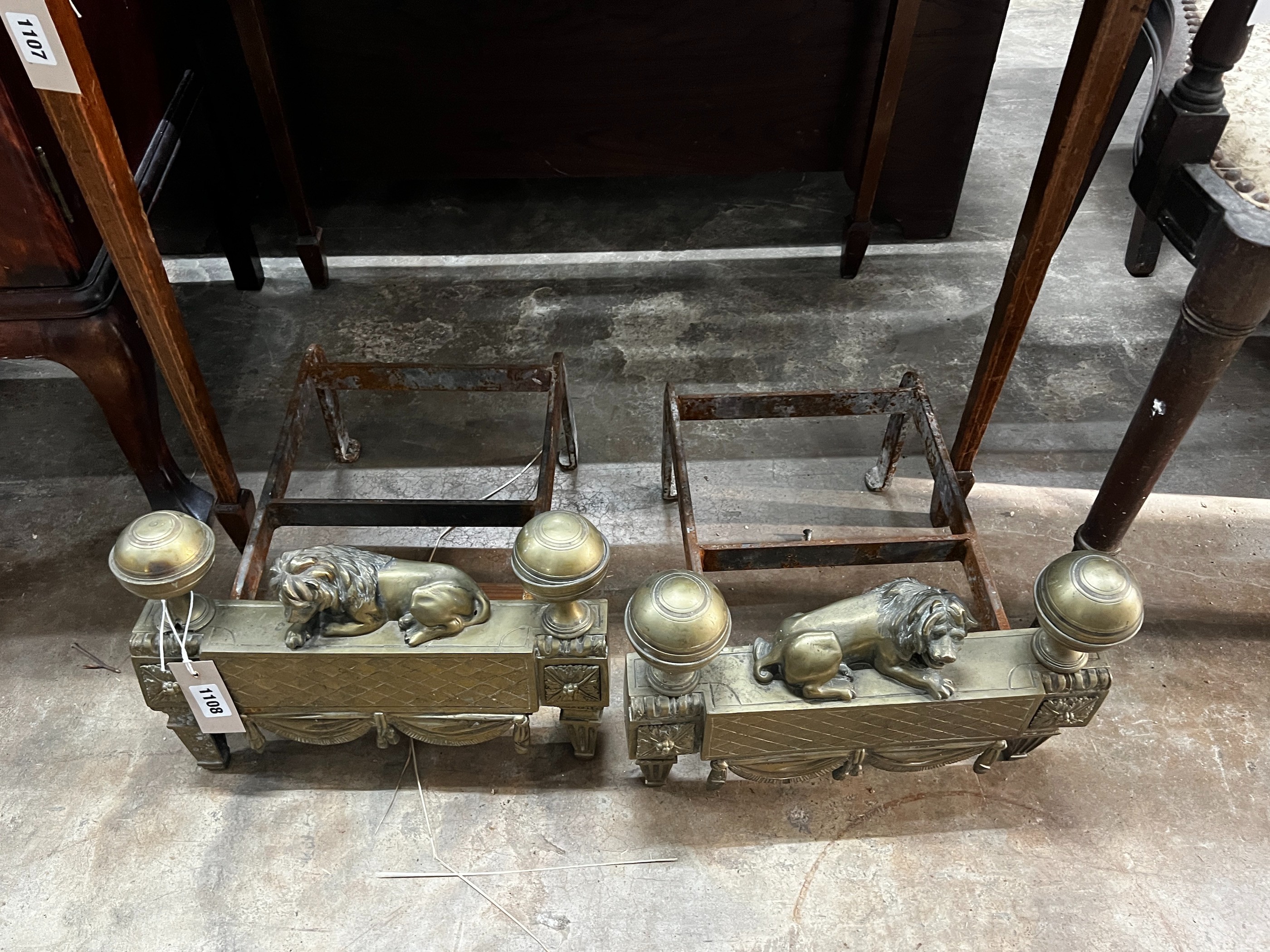 A pair of 19th century wrought iron and brass recumbent lion fire dogs, width 34cm, depth 36cm